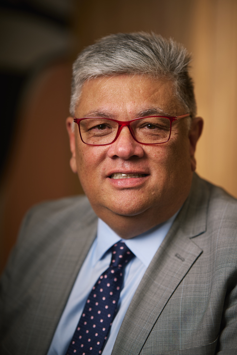 Headshot of Simon Tse wearing glasses and a suit